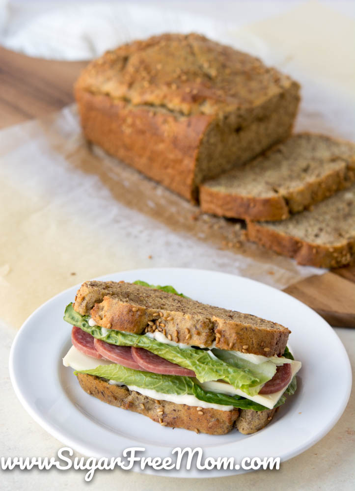 sandwich on a plate with loaf of bread in background